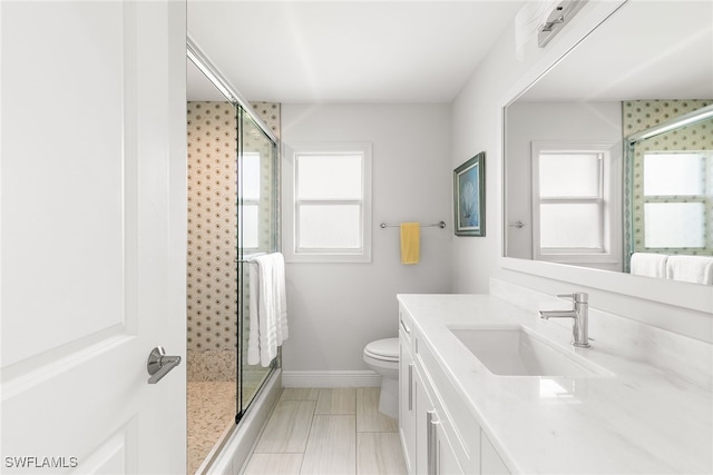 bathroom with plenty of natural light, a shower with shower door, and toilet