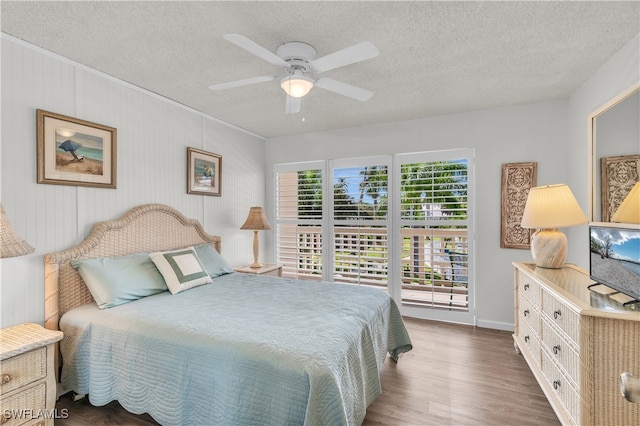 bedroom featuring dark hardwood / wood-style flooring, ceiling fan, and a textured ceiling