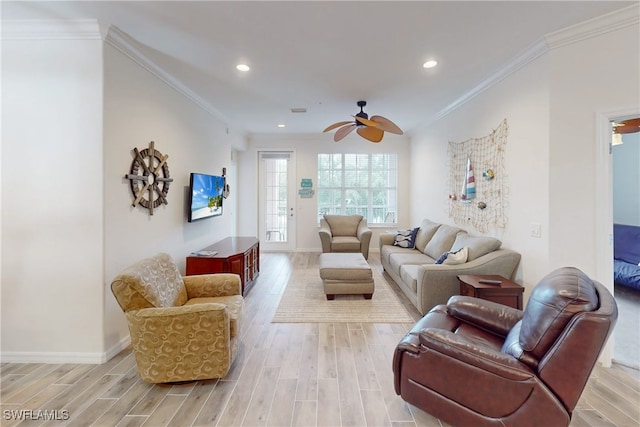 living room featuring ceiling fan, crown molding, and light wood-type flooring