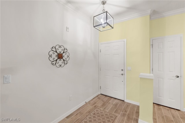 entryway featuring light hardwood / wood-style flooring, crown molding, and a chandelier