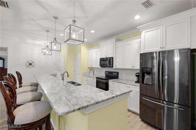 kitchen with a breakfast bar, sink, light hardwood / wood-style floors, stainless steel appliances, and white cabinets