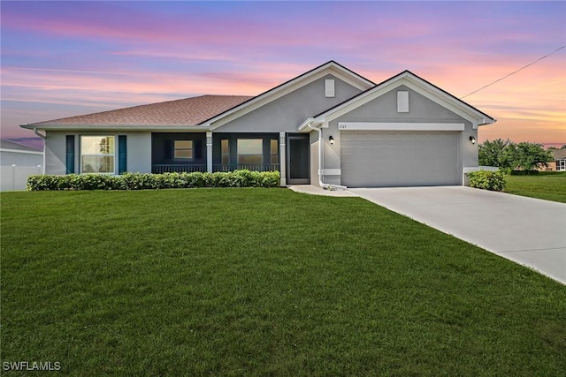 ranch-style home with a yard and a garage