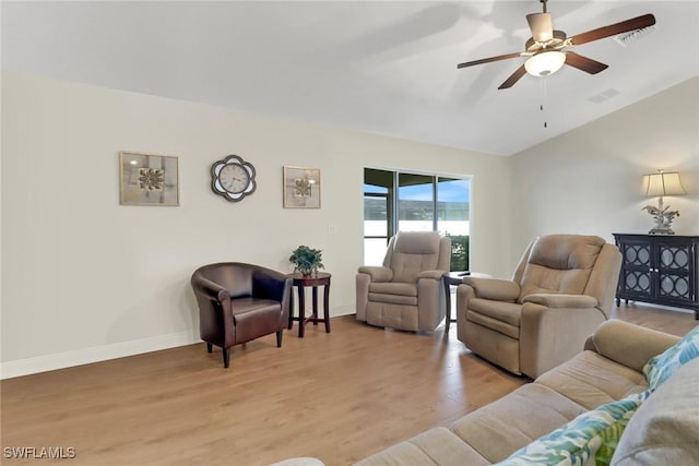 living room featuring lofted ceiling, ceiling fan, and light hardwood / wood-style flooring