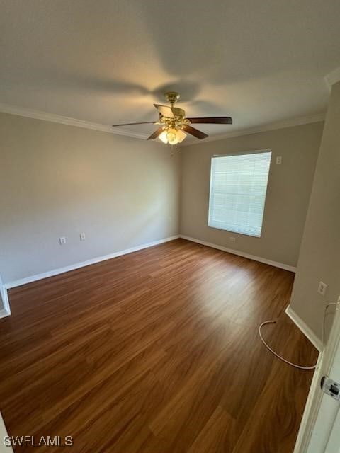 empty room featuring ornamental molding, ceiling fan, and dark hardwood / wood-style floors