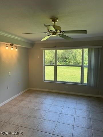 tiled spare room featuring ornamental molding and ceiling fan