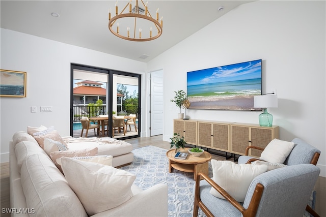 living room featuring a notable chandelier, lofted ceiling, and hardwood / wood-style flooring