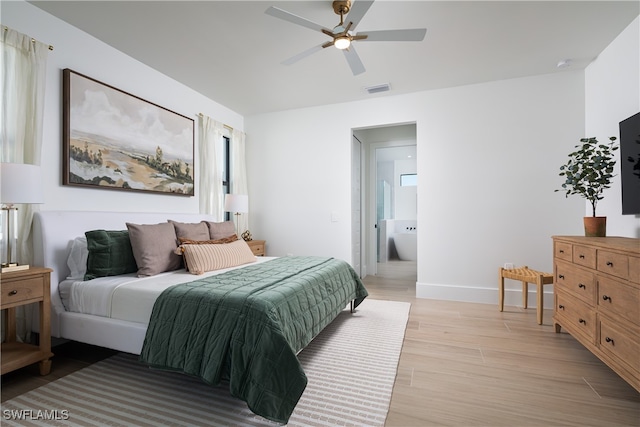 bedroom featuring ceiling fan, light hardwood / wood-style flooring, and ensuite bath