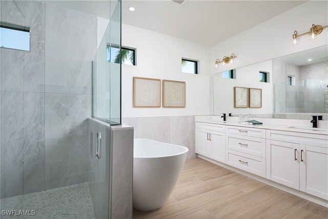 bathroom featuring vanity, shower with separate bathtub, tile walls, and hardwood / wood-style floors