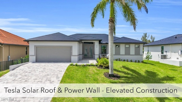 view of front of property featuring central AC unit, a front yard, and a garage