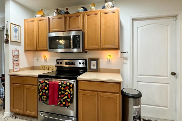 kitchen with stainless steel appliances and light tile patterned flooring