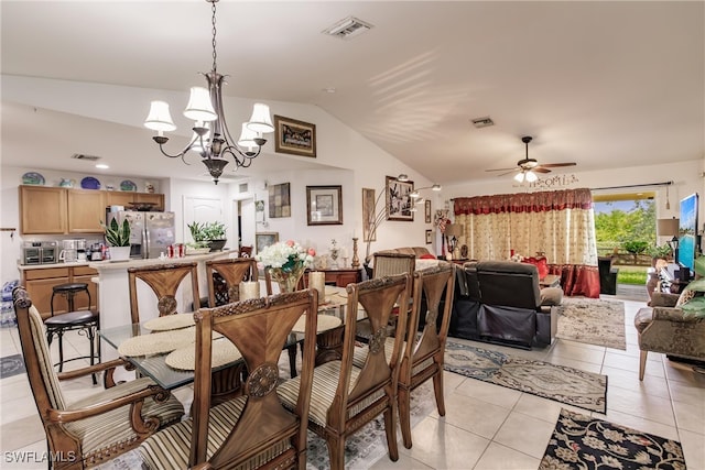 dining area with vaulted ceiling, ceiling fan with notable chandelier, and light tile patterned flooring