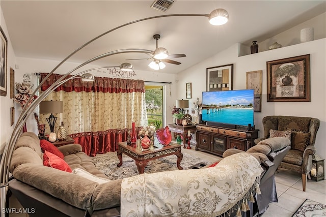 living room with ceiling fan, vaulted ceiling, and light tile patterned floors