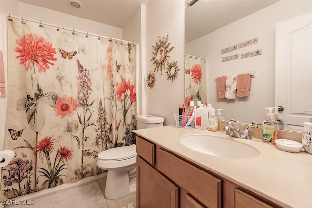 bathroom with tile patterned flooring, toilet, vanity, and curtained shower