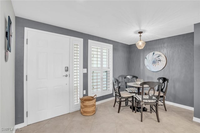 dining space featuring light tile patterned flooring and baseboards