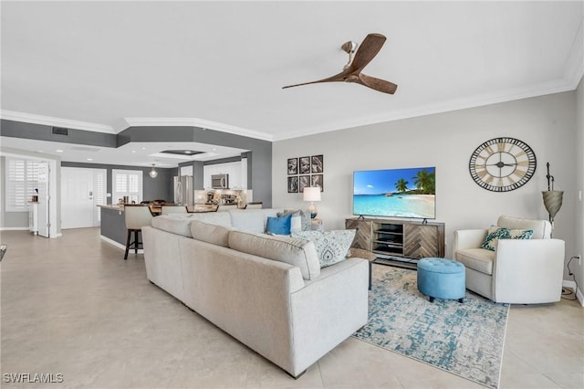 living room with ceiling fan, light tile patterned flooring, visible vents, baseboards, and crown molding