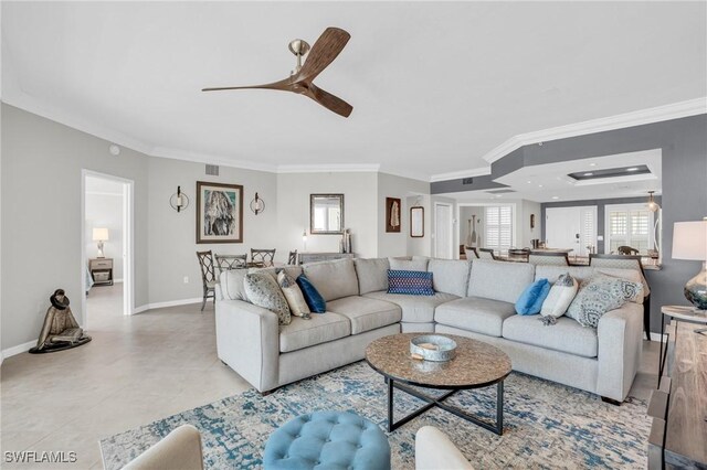 tiled living room with ceiling fan and crown molding