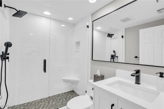 bathroom with recessed lighting, visible vents, toilet, a stall shower, and vanity