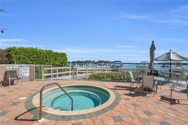 view of pool featuring a patio, a hot tub, and a water view