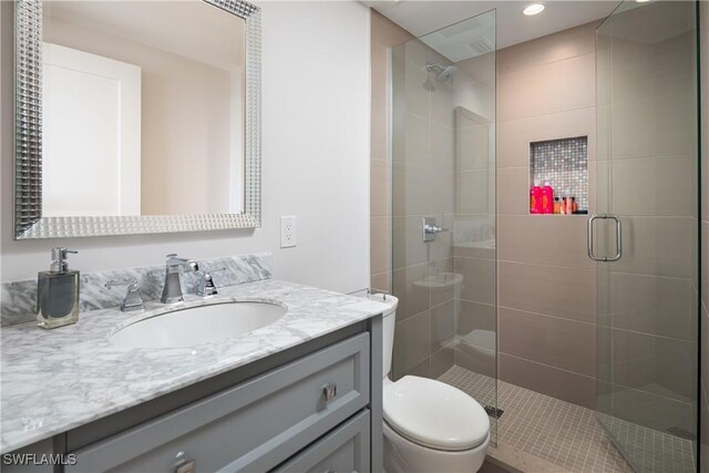 bathroom featuring a stall shower, vanity, toilet, and recessed lighting