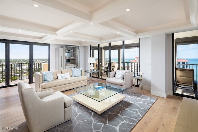 living room featuring coffered ceiling, hardwood / wood-style floors, a wall of windows, a water view, and beamed ceiling