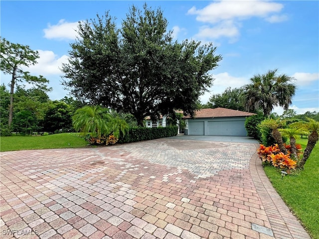 view of front of home with a garage and a front lawn