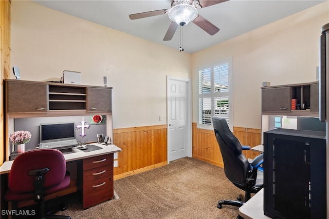 office with a wainscoted wall, light carpet, a ceiling fan, and wooden walls