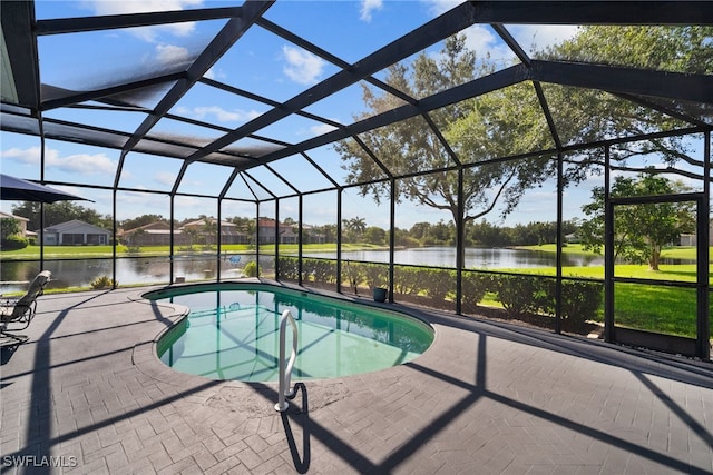 pool featuring a patio area, glass enclosure, and a water view