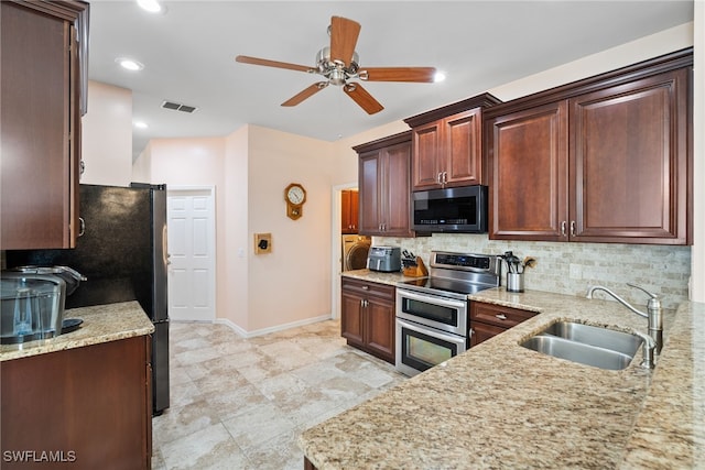 kitchen with tasteful backsplash, visible vents, a sink, double oven range, and baseboards