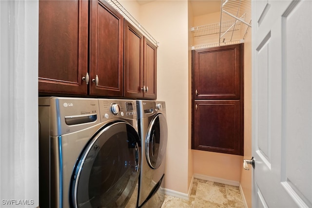 laundry room with separate washer and dryer, cabinet space, and baseboards