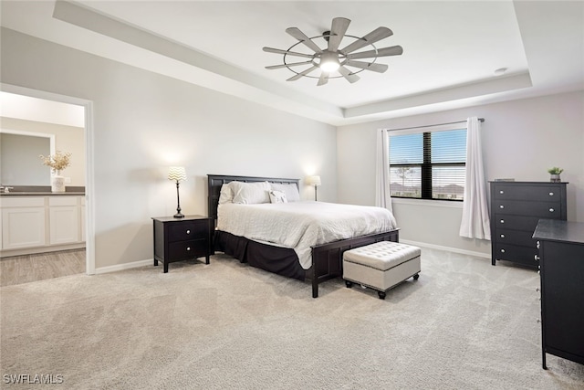 bedroom featuring baseboards, a raised ceiling, and light colored carpet