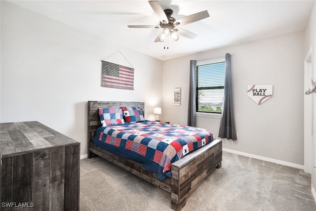 bedroom featuring light carpet, a ceiling fan, and baseboards