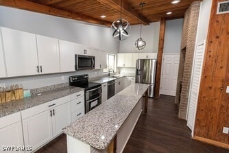 kitchen with wood ceiling, beamed ceiling, appliances with stainless steel finishes, dark wood-style floors, and a center island