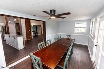 dining area with a textured ceiling, a ceiling fan, dark wood-style flooring, and baseboards