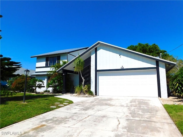 view of front facade featuring a front yard, driveway, and an attached garage
