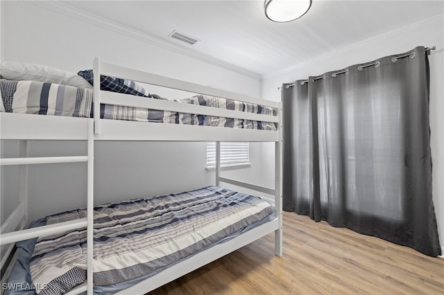 bedroom featuring ornamental molding and wood-type flooring