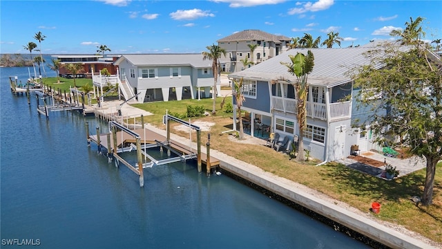 back of house featuring a water view and a lawn