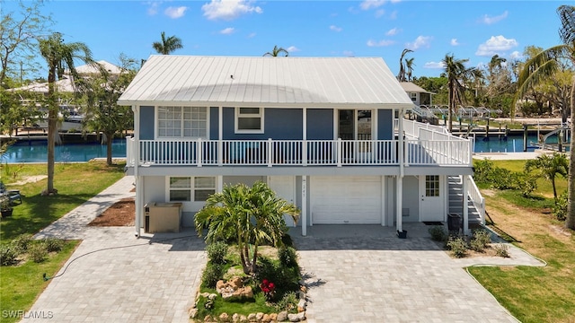 raised beach house featuring a water view and a garage