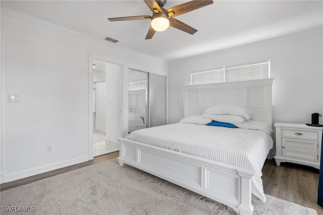 bedroom featuring ornamental molding, hardwood / wood-style floors, ceiling fan, and ensuite bath