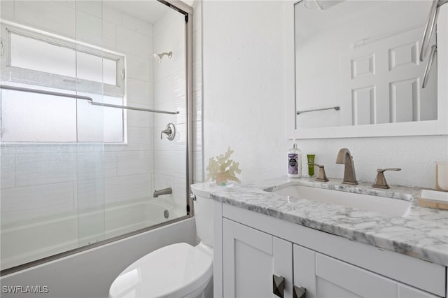 full bathroom with vanity, shower / bath combination with glass door, and toilet