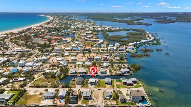 birds eye view of property featuring a water view and a beach view