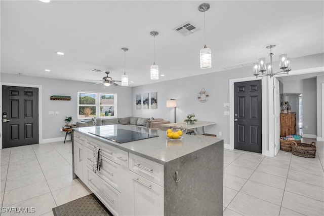 kitchen featuring a center island, hanging light fixtures, light tile patterned floors, black electric cooktop, and white cabinets