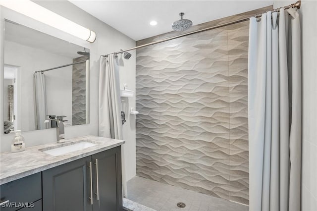 bathroom featuring walk in shower and vanity