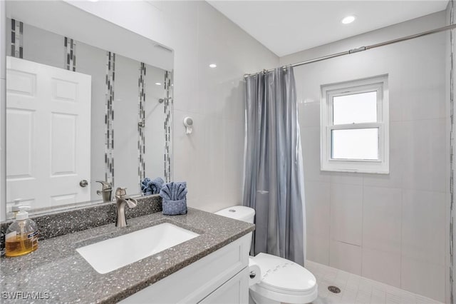 bathroom with vanity, curtained shower, tile walls, and toilet