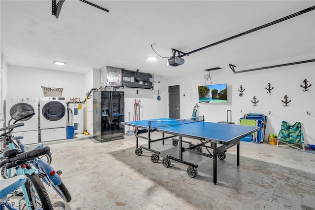 playroom with concrete flooring, electric water heater, and washer and dryer