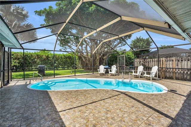 view of swimming pool with a lanai, a patio, and fence