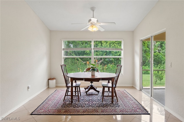 tiled dining space featuring ceiling fan and lofted ceiling