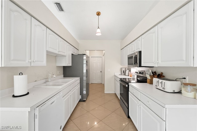 kitchen with white cabinets, hanging light fixtures, light tile patterned floors, sink, and stainless steel appliances