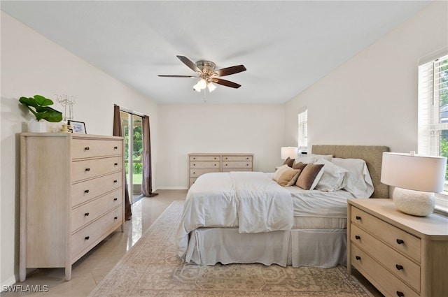 bedroom featuring access to exterior, light tile patterned floors, and ceiling fan