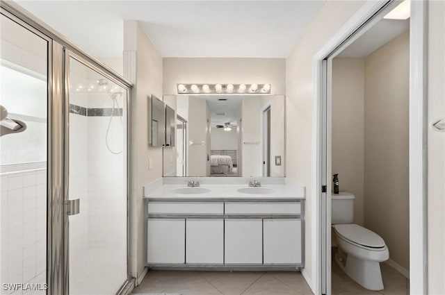 bathroom with ceiling fan, vanity, a shower with shower door, and toilet