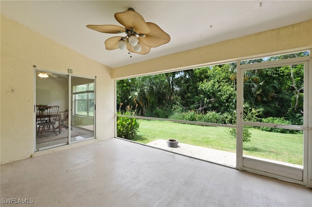 unfurnished sunroom with ceiling fan and vaulted ceiling